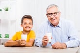Grandpa and grandson drink glasses of milk alternative