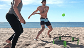 People playing Slammo game at the beach.