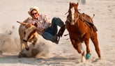 Cowboy flying off a horse at rodeo