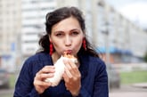 A woman eats a burrito