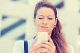 Woman looking skeptical on cellphone
