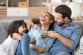 family tickling laughing sitting couch daughter home family