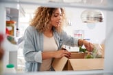 Woman unpacking a home delivery meal kit