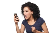 Angry woman looks at phone