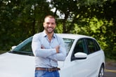 Happy man in front of a car