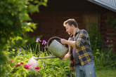 Man watering flowers in his yard
