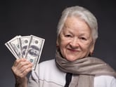Smiling senior woman holding money