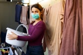 a woman does laundry in a mask