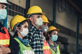 A group of construction workers in face masks are unemployed because of COVID-19