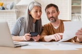 Couple reviewing financial documents in their kitchen
