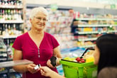 Senior woman earning grocery cash back rewards at the store