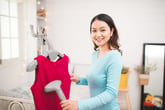 Woman with clothes steamer