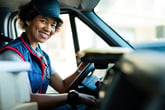 Female courier and package delivery driver in a truck