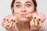 Woman eating glazed doughnuts