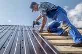 Construction worker installing a metal roof
