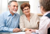 Senior couple making retirement plans with adviser