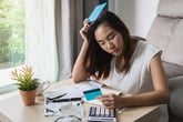 Stressed woman looking at bills and credit card