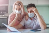 Couple in mask worrying about their finances