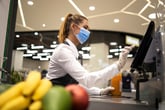 Grocery store cashier working in a mask and gloves