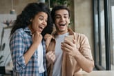 Excited couple looking at a phone