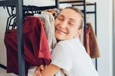 Woman hugging clothes in her closet