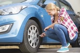 Woman checking air pressure on tires