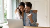 excited couple with computer laptop