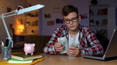 Teenager counting money for college
