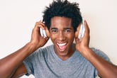 Smiling man listening to music with headphones