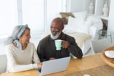 senior couple drinking coffee on computer