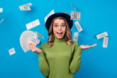 Excited woman holding lots of money and money raining from above