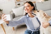 Woman taking cellphone selfie with her dog