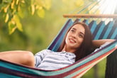 Happy woman relaxing in a hammock outdoors