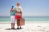 Couple retiring overseas and standing on the beach