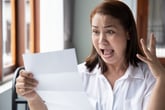 Shocked woman opening a notice