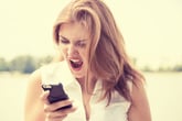 Angry woman screaming at her smartphone