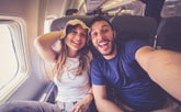Excited couple on a plane enjoying a flight