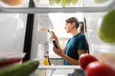 Woman checking fridge for expired food