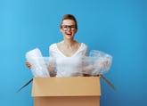 Excited woman with bubble wrap and packing material
