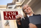 Real estate agent with "for sale" sign