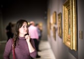 woman looking at painting in a museum