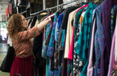 Woman browsing clothing racks at a thrift store
