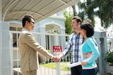 Excited couple purchasing a home and shaking hands