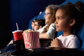 A little girl watching a movie in a theater