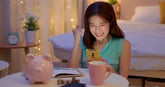 Happy woman looking at phone excited about her savings