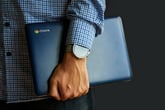 Hand holding a Chromebook laptop