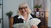 Older woman smiling with lots of extra money