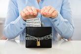 Man guarding the money in his wallet and protecting it with a lock and chain