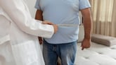 Doctor measuring the waist of an overweight patient