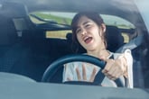 Frustrated female driver stuck in traffic screaming and honking horn